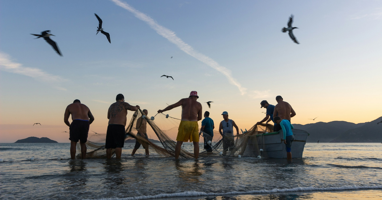 Pescadores puxando rede ao amanhecer